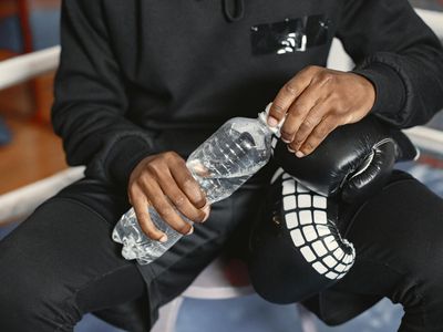 Person hands holding a water bottle during break